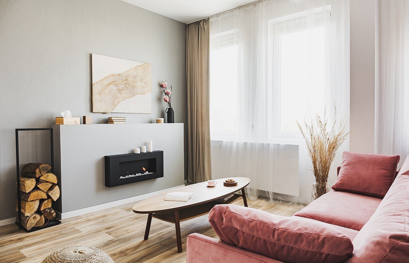 Stylish living room interior with pastel pink sofa, wooden coffe